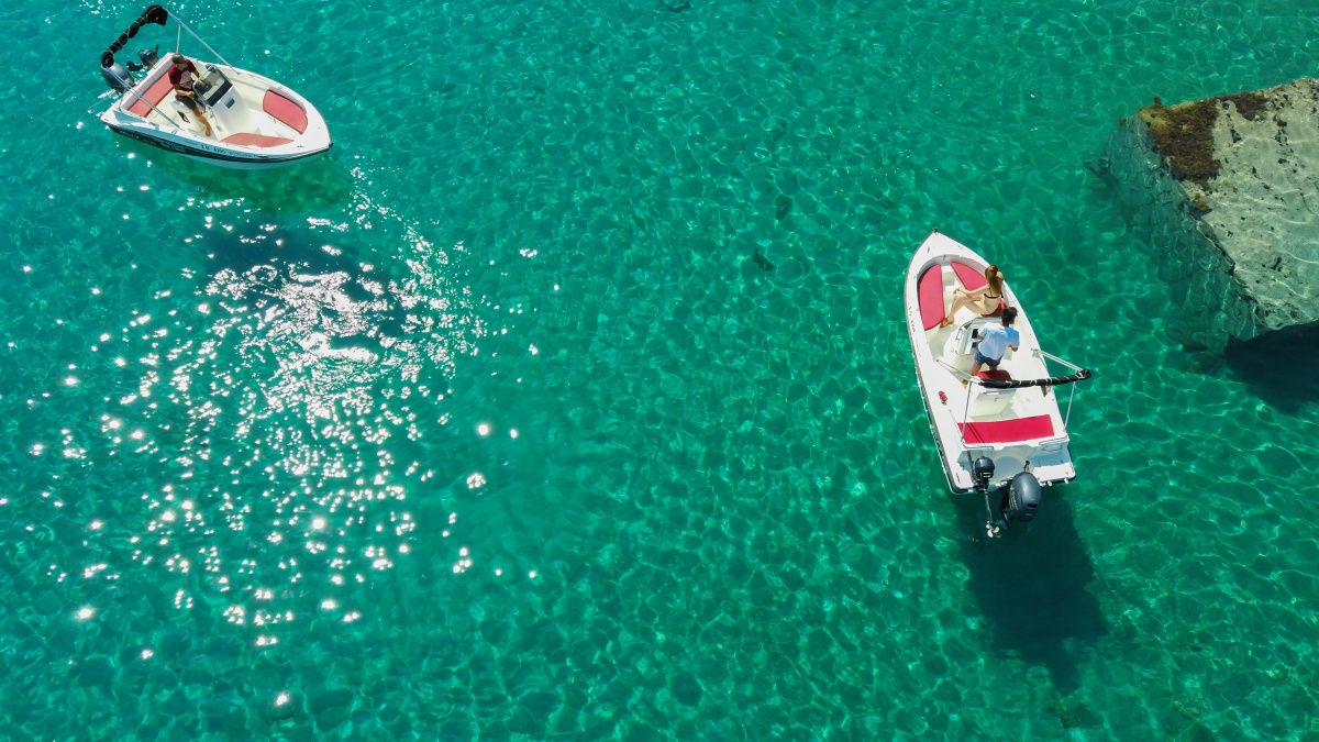 aerial-shot-of-people-driving-motorboats-on-a-transparent-sea.jpg